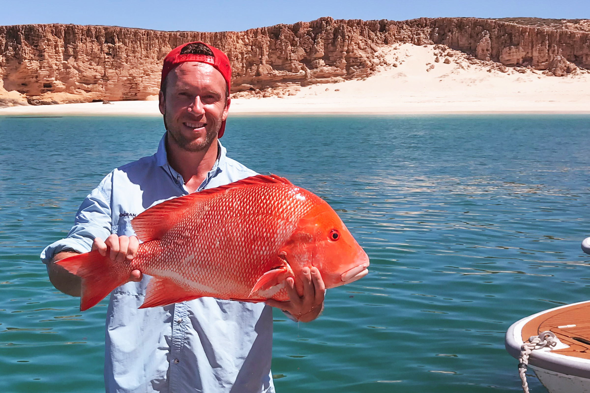man holding a red snapper