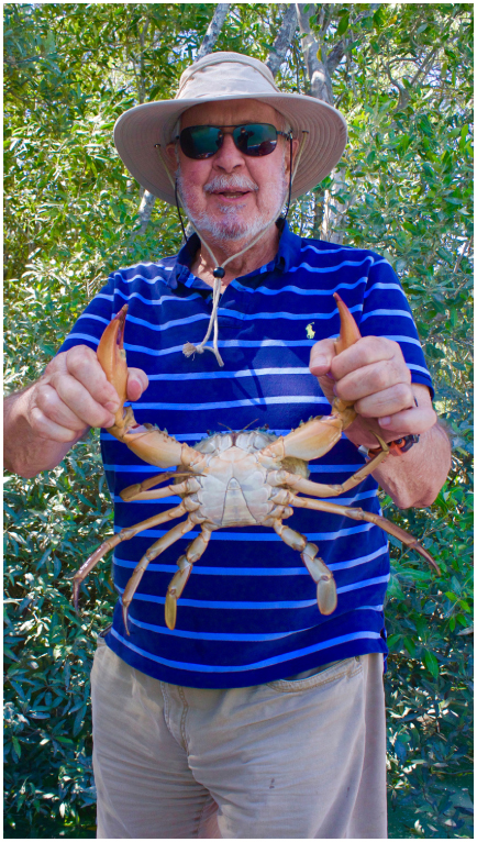 a man posing with a crab