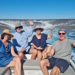 people posing on the back of a boat on Montgomery Reef