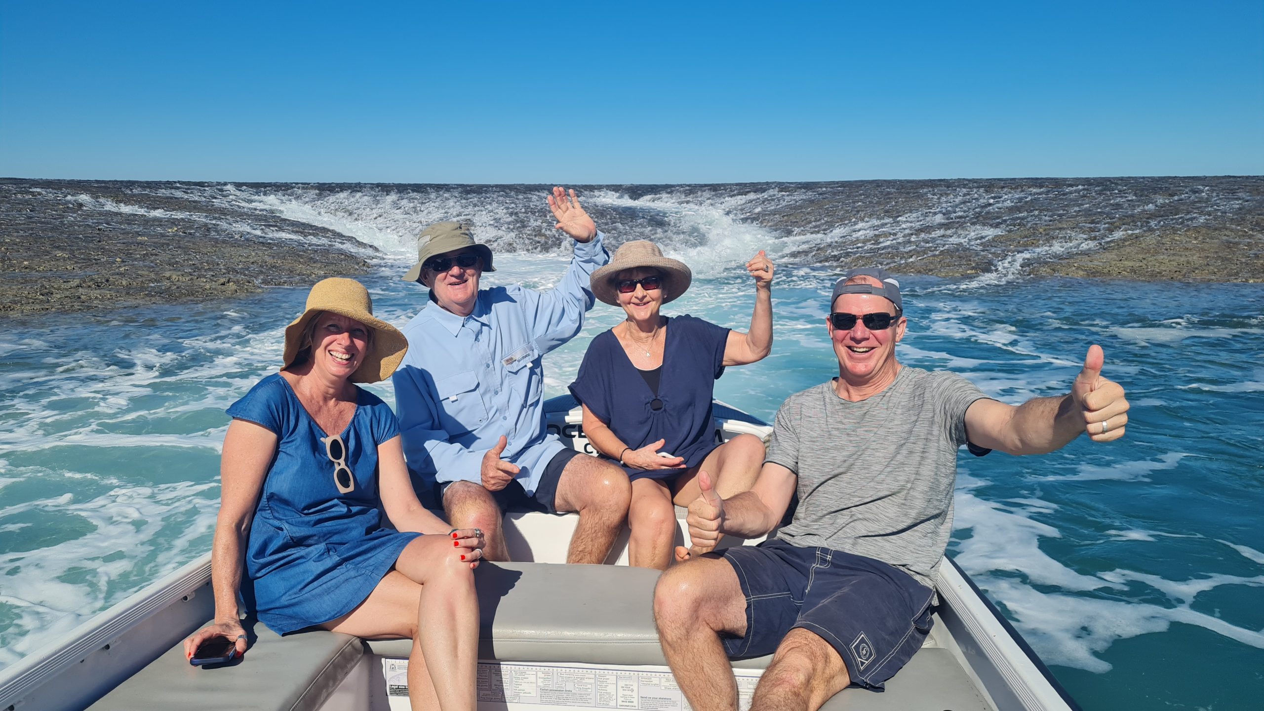 people posing on the back of a boat on Montgomery Reef