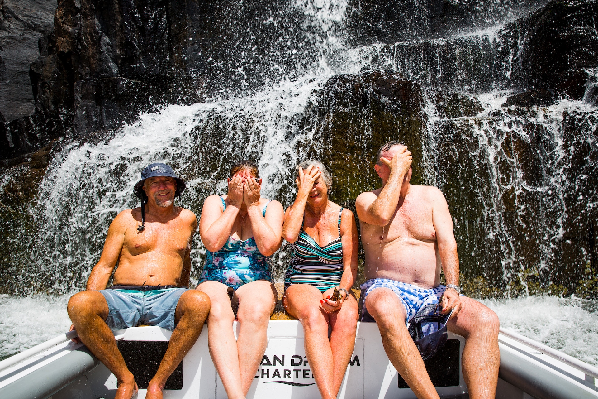 Guests sitting under a waterfall on Ocean Dream Charters